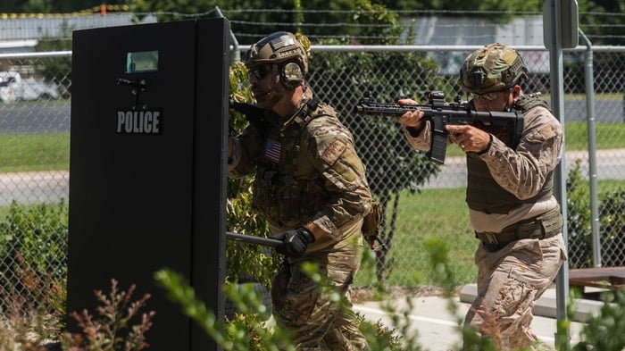 Police officers advancing behind a level 4 ballistic shield during a tactical operation for high-threat protection